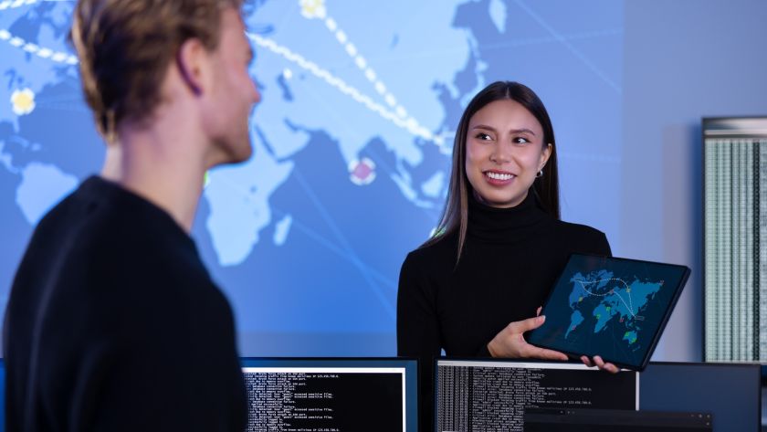 Smiling cyber security team working in a Cyber Security Operations Center SOC to protect systems and
