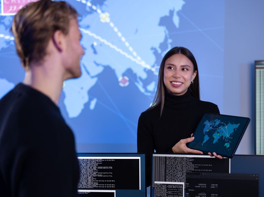 Smiling cyber security team working in a Cyber Security Operations Center SOC to protect systems and