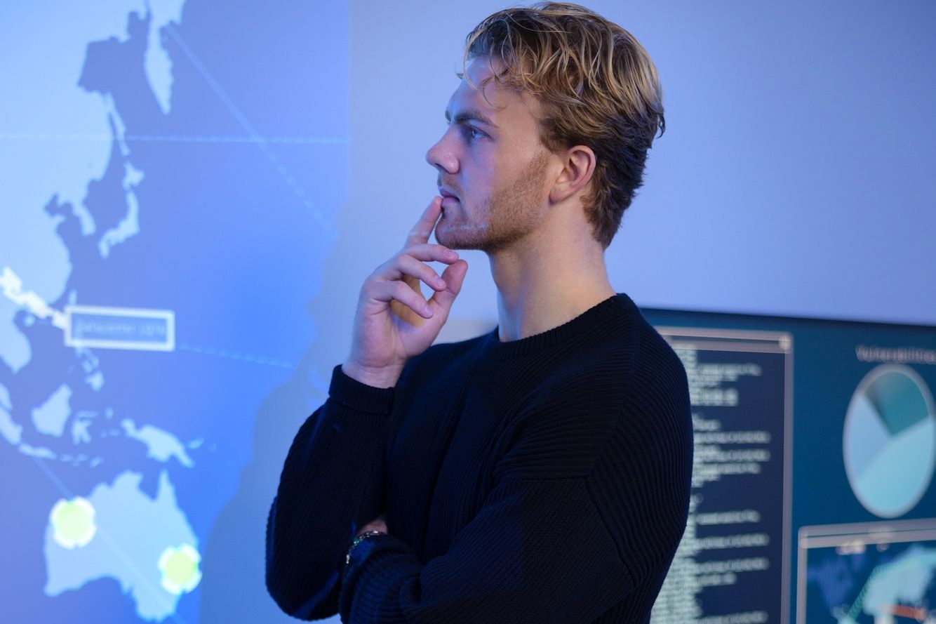 Thoughtful Cyber Security Control Center Operator Working. Multiple Screens Showing Technical Data